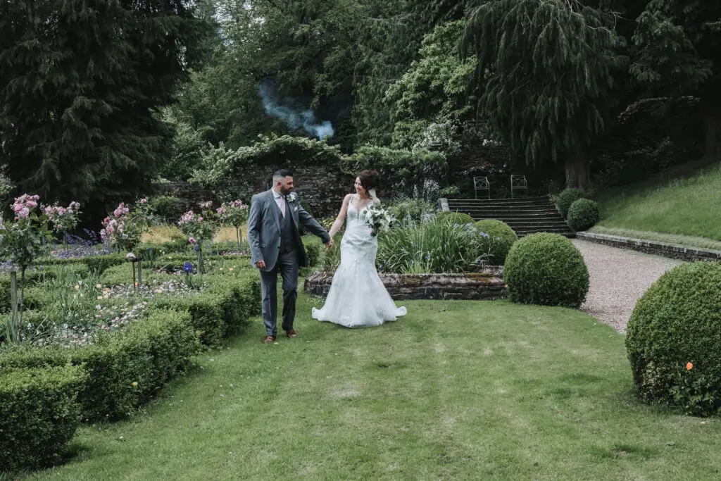 Newlyweds walking through wedding gardens